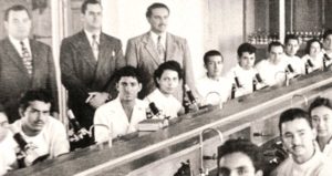 Primera clase de Laboratorio de Histología. De pie, el profesor, Rubén Lagunes Lagunes, una persona no identificada y el gobernador Marco Antonio Muñoz Turnbull, Facultad de Medicina, Veracruz, Ver. enero de 1952.